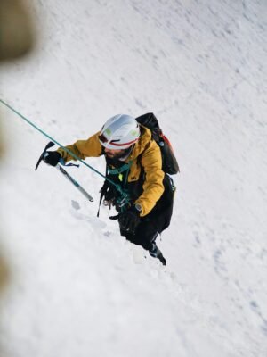 A person climbing up a snowy slope with a backpack