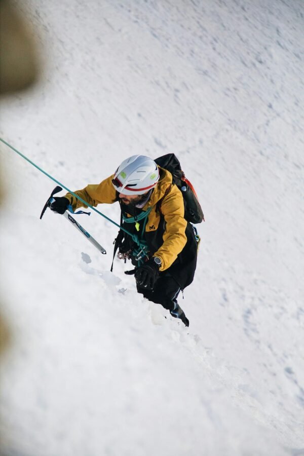 A person climbing up a snowy slope with a backpack