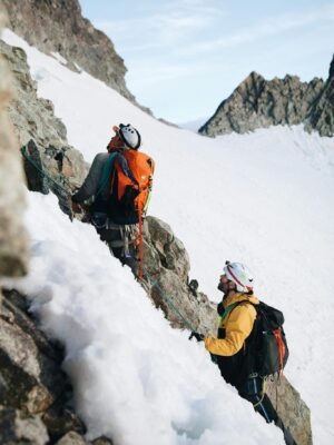 Two climbers on a snowy mountain with backpacks