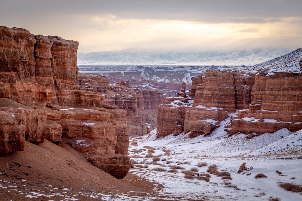 A breathtaking view of a snow-dusted canyon during sunset, showcasing nature's beauty.